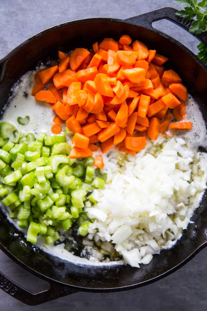 celery, carrots, and onion in a skillet with butter