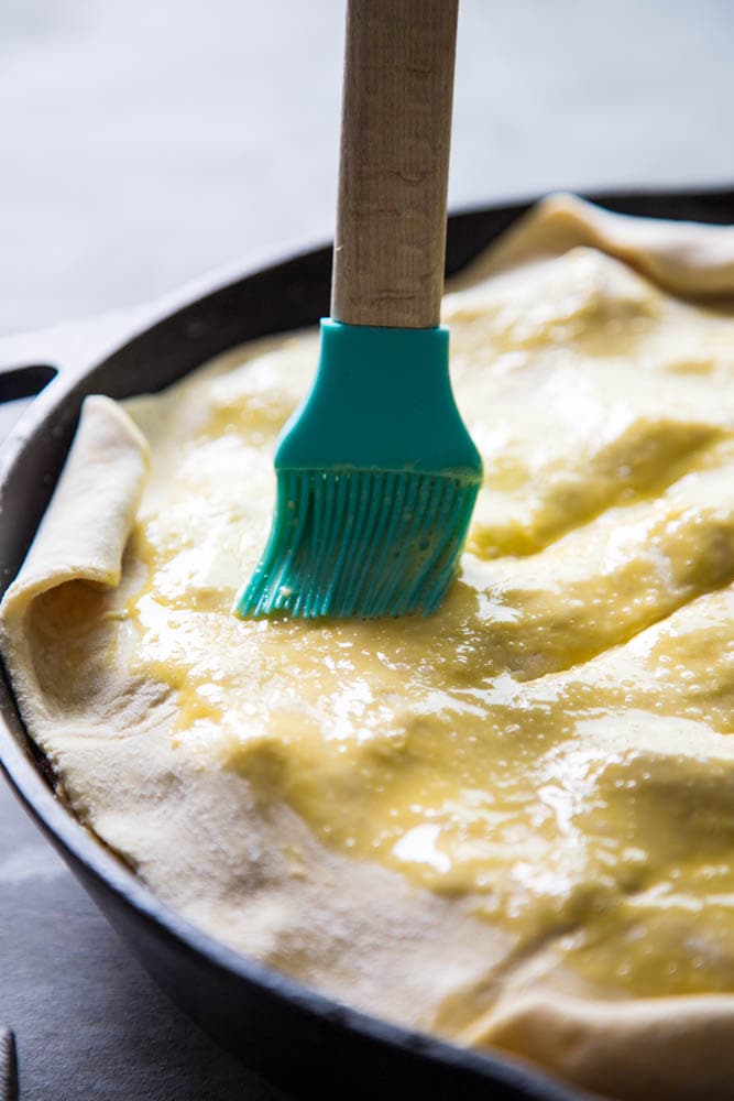 dough being brushed with butter