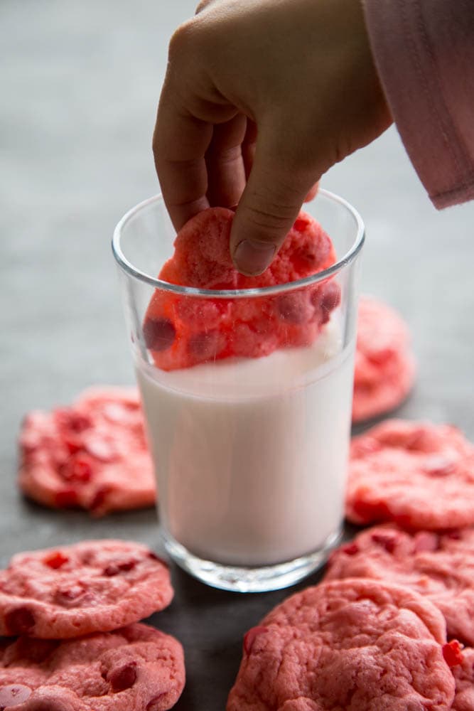 a cookie being dunked in a glass of milk