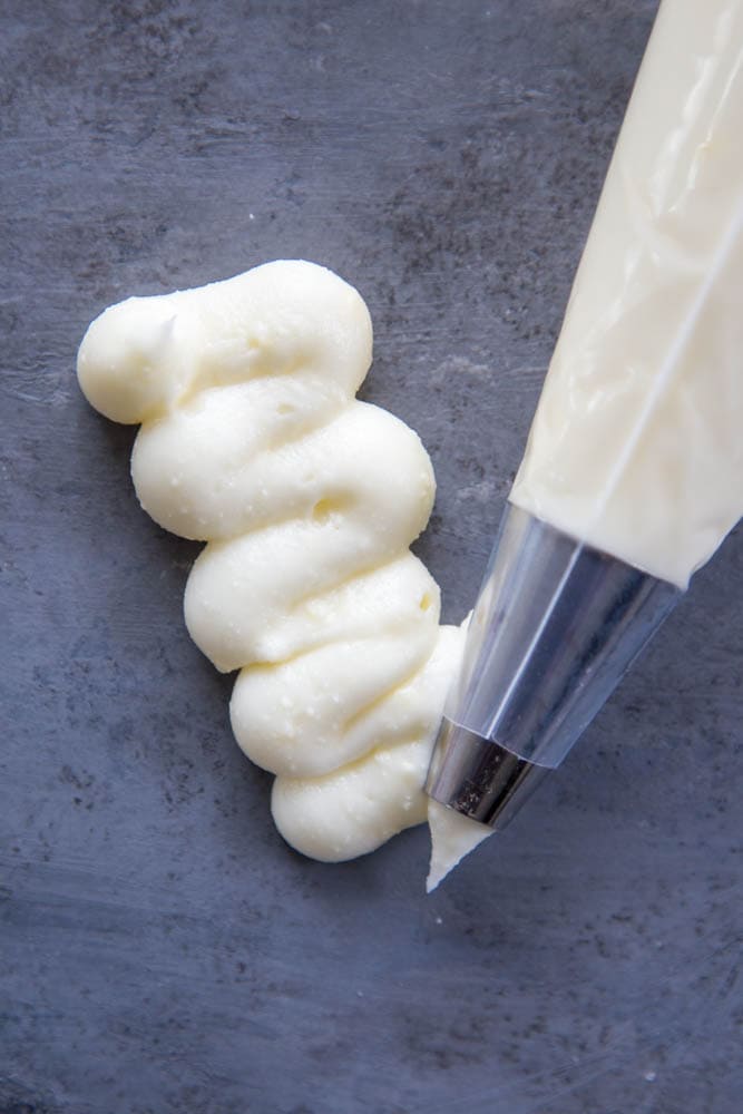 cream cheese frosting piped onto a surface.