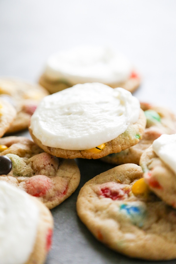 assortment of M&M cookies with buttercream frosting