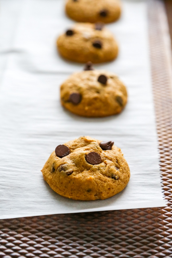 baked cookies lined up on the parchment paper.