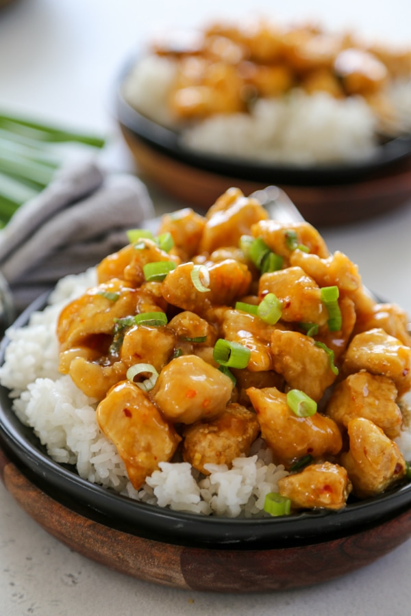 orange chicken on a plate with rice.