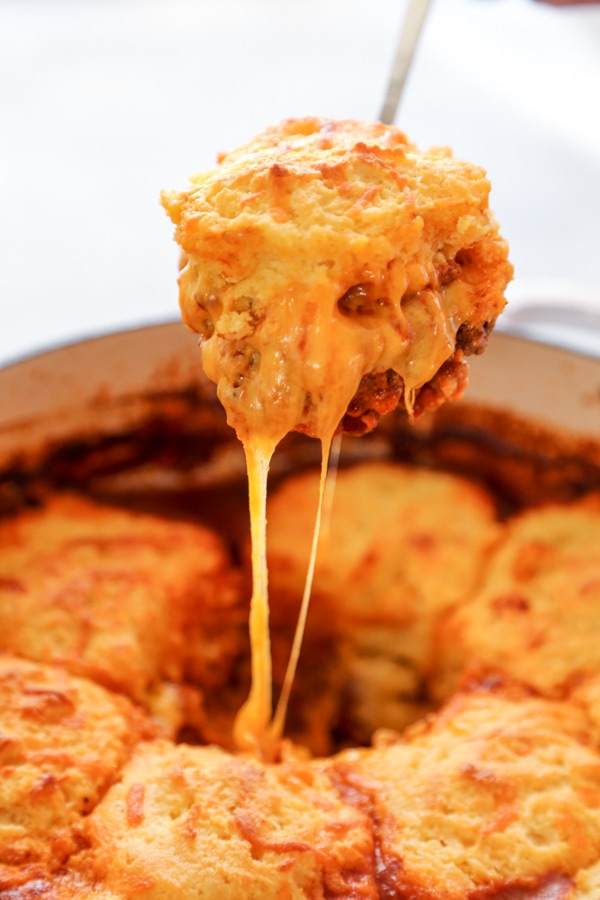 a scoop of chili cheese bake being lifted out of the pan.