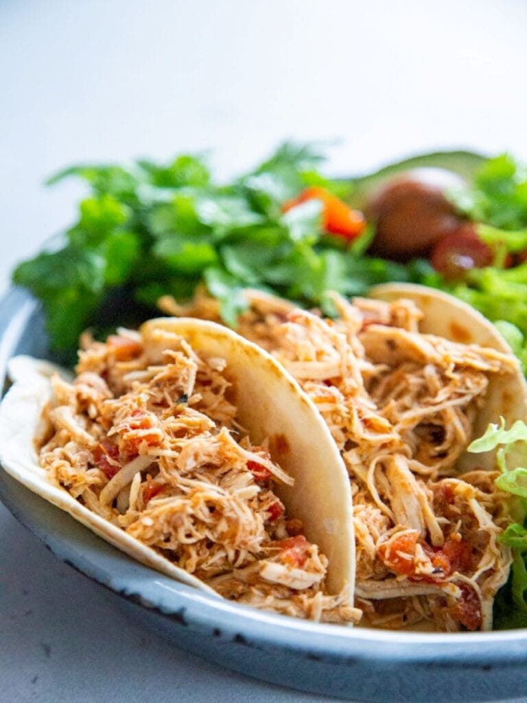 close up shot of chicken tacos on plate with lettuce
