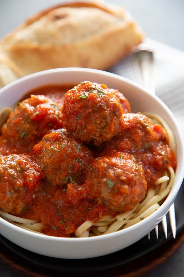 meatballs piled on top of spaghetti in a bowl.