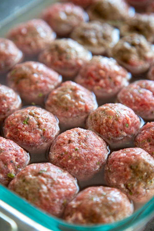 meatballs in a baking dish with water.