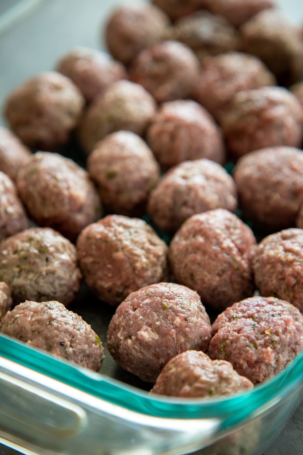 the par cooked meatballs in a baking dish.