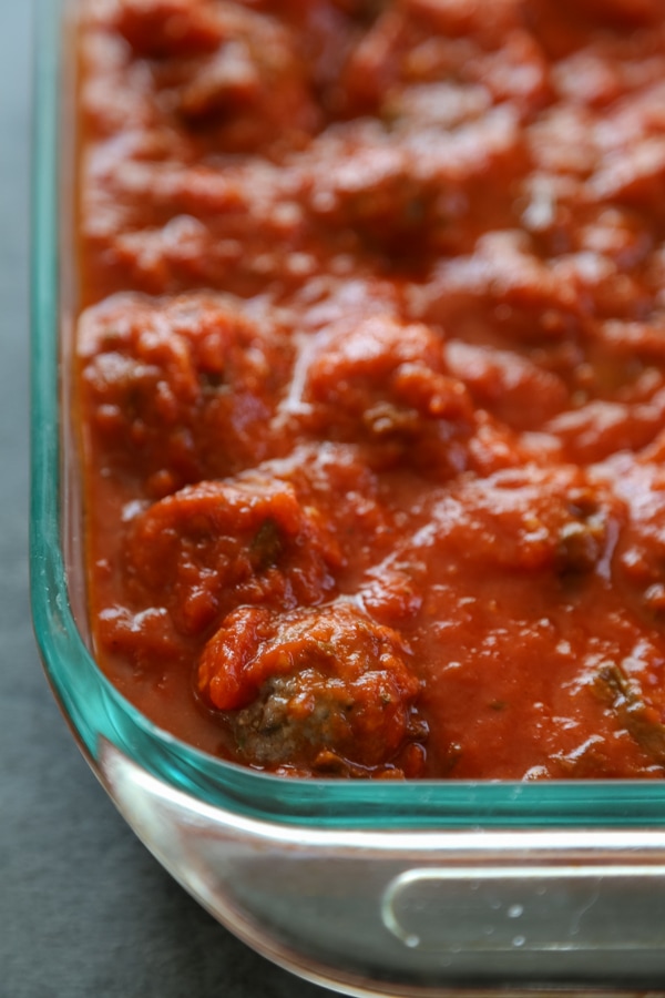 meatballs in a baking dish covered with sauce.