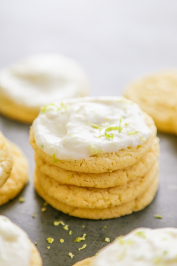 Key Lime Sugar Cookies stacked with a frosted one on top.