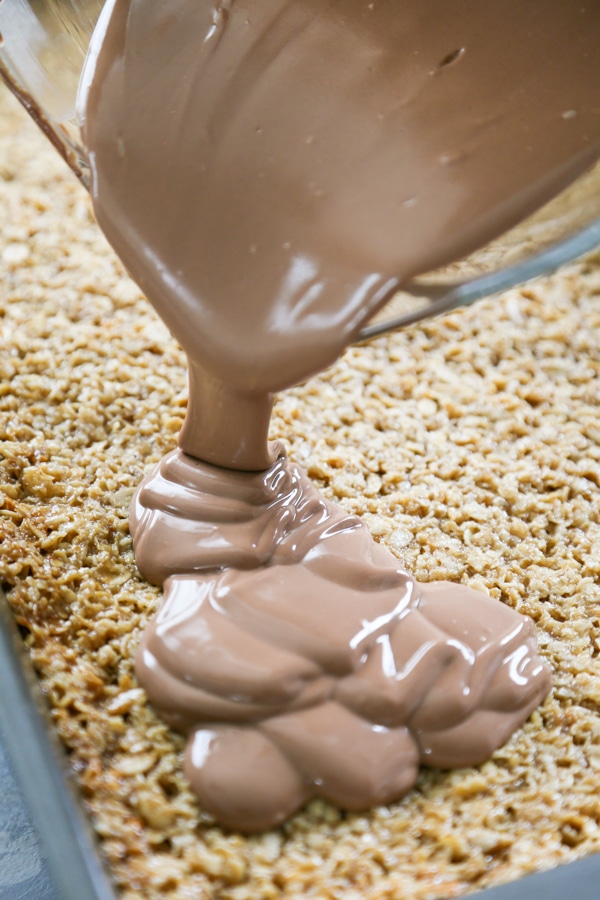 Nutella topping being poured over the oatmeal bars.