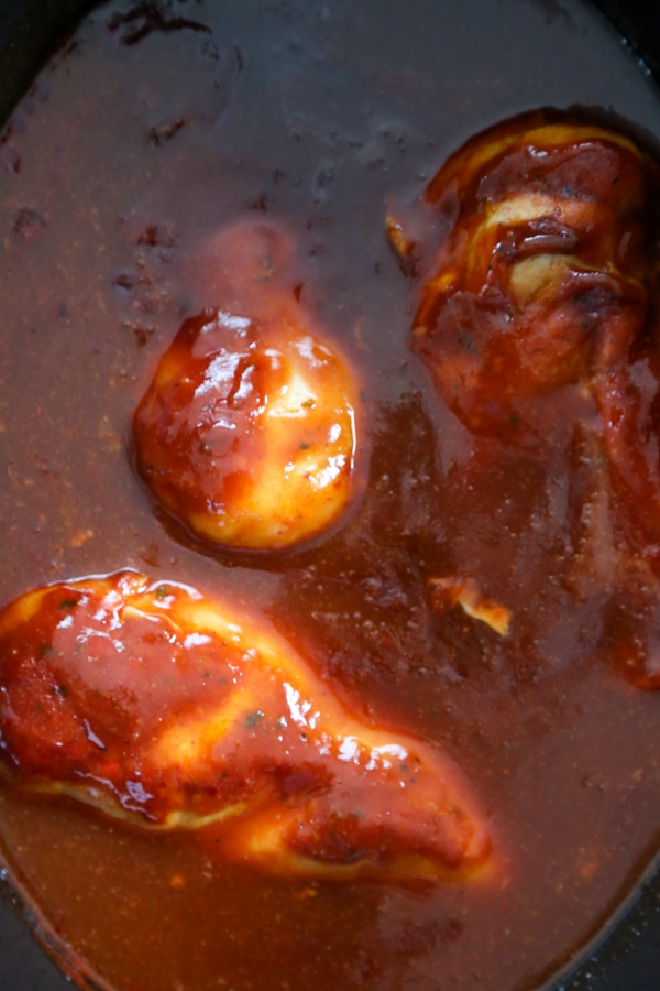 overhead shot of the cooked chicken in the slow cooker with sauce.