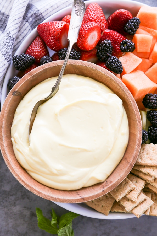 overhead shot of a bowl of fruit dip with fruit on the side.