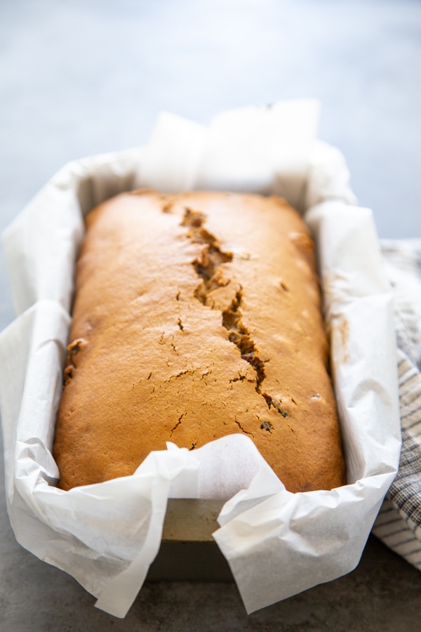 close-up of the bread loaf in a pan lined with parchment paper.