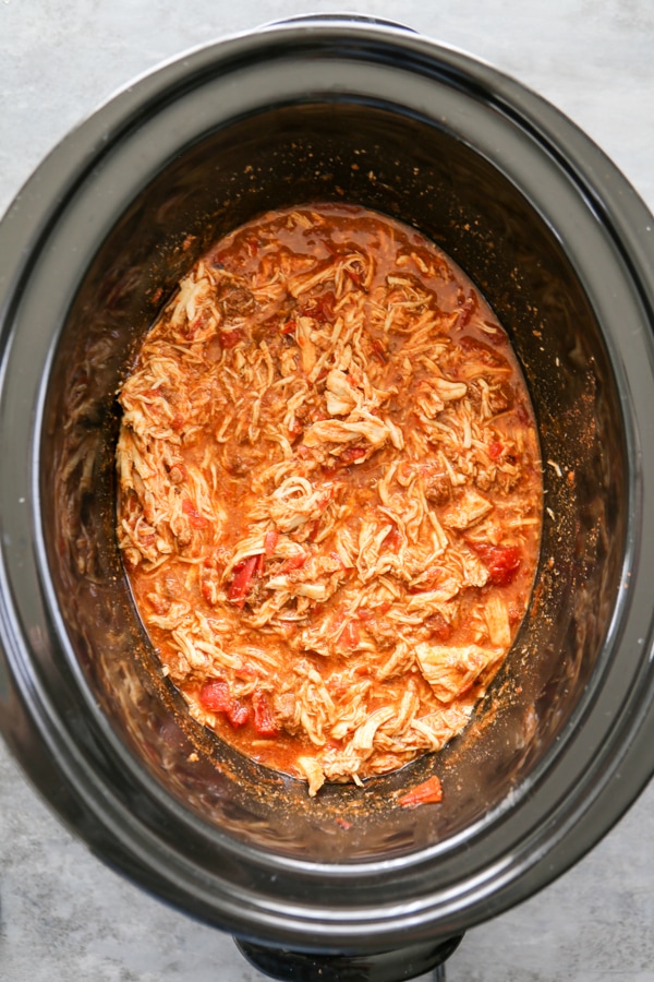 overhead shot of the shredded chicken in the slow cooker with chili.