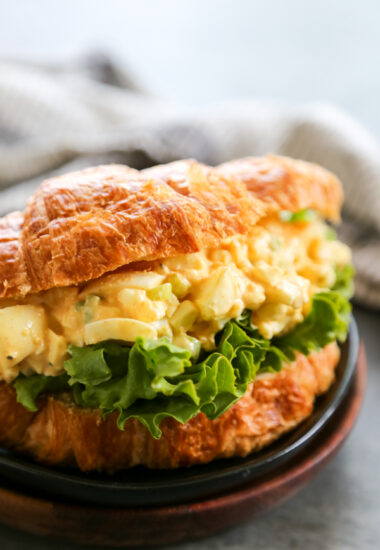 egg salad on a croissant with lettuce.
