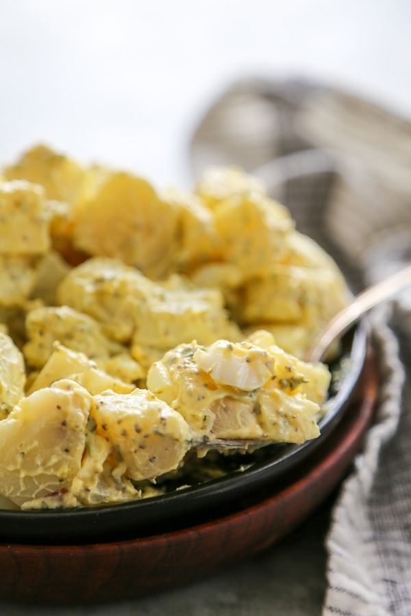 close-up shot of potato salad on a plate with a fork.