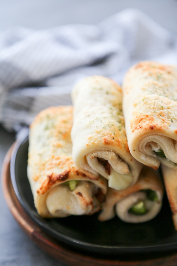 stuffed breadsticks stacked on a plate.