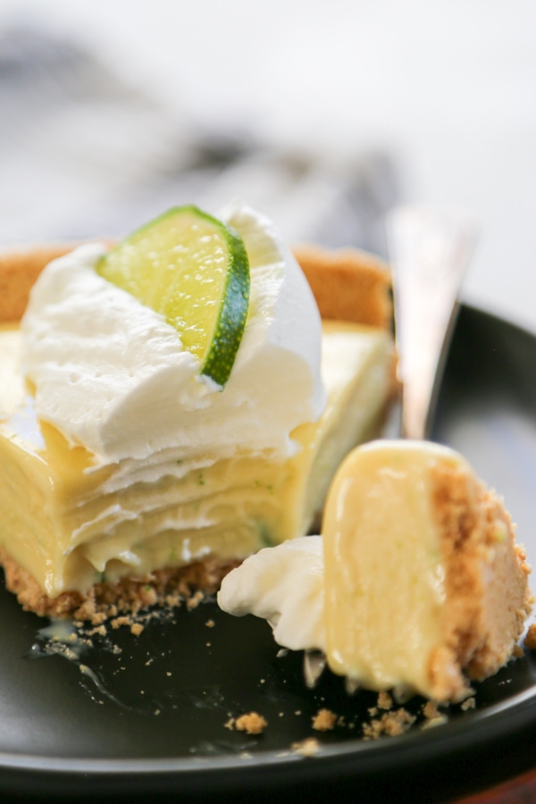 a bite of pie on a fork with the slice on a plate.