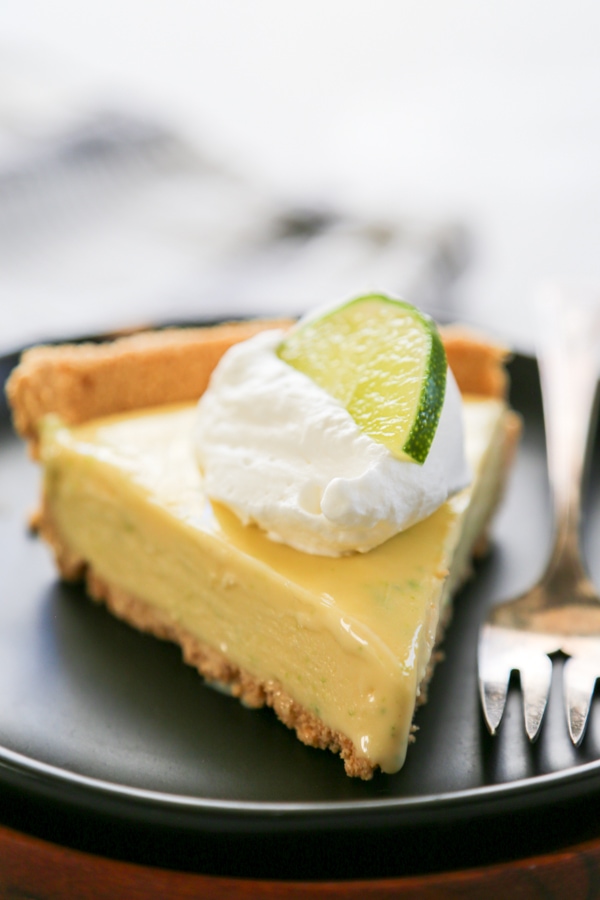 a slice of pie topped with whipped cream and a lime slice.