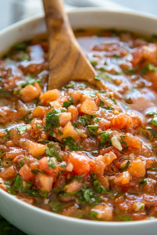 Margherita sauce shot in white bowl and wooden serving spoon