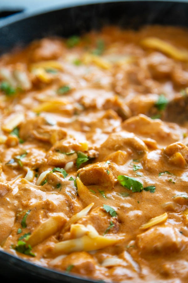 creamy salsa chicken in skillet with wooden spoon