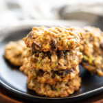 zucchini oatmeal raisin cookies staked on a black plate