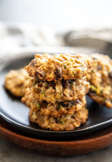 zucchini oatmeal raisin cookies staked on a black plate