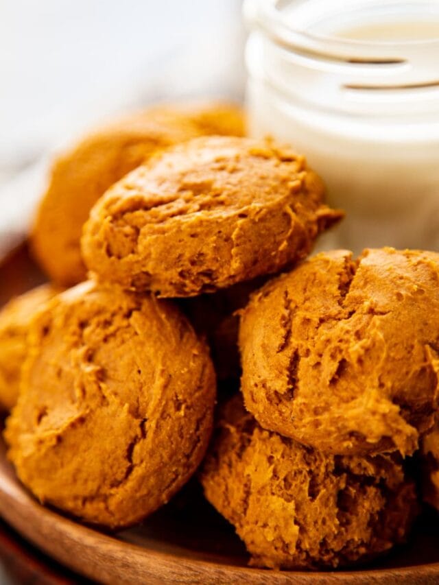 stack of pumpkin cookies with glass of milk