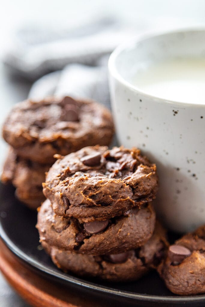 chocolate pumpkin cookies next to glass of milk