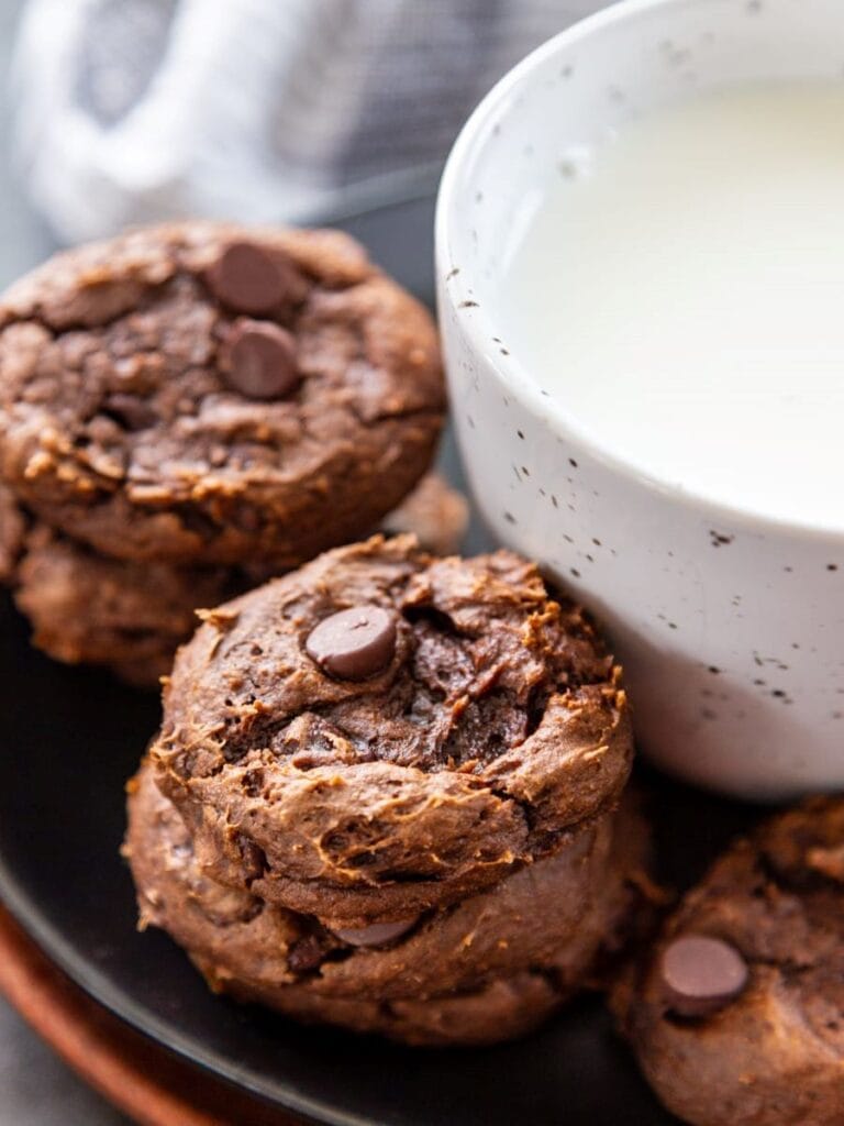 chocolate pumpkin cookies next to glass of milk