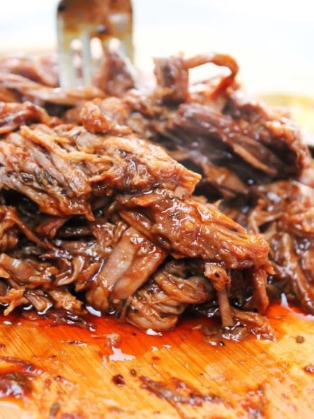 close up shot brisket on cutting board shredded