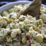southwest potato salad in serving bowl with wooden spoon