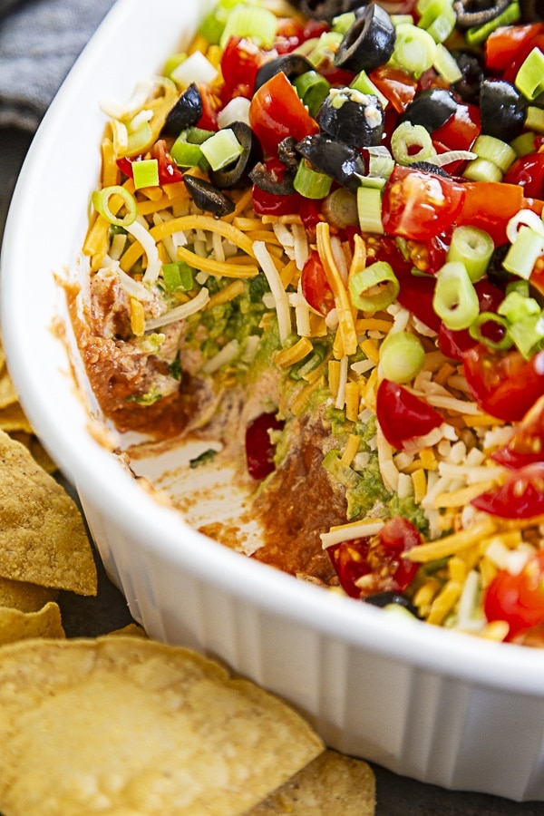 7 layer dip in dish with scoop taken out