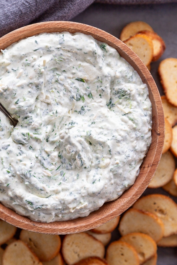 overhead shot of spinach artichoke dip with crackers