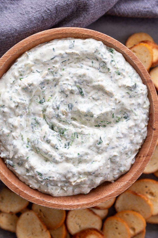 spinach artichoke dip in wood bowl with chips