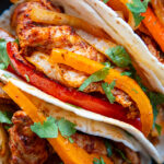 overhead close up shot of chicken fajitas in flour tortilla