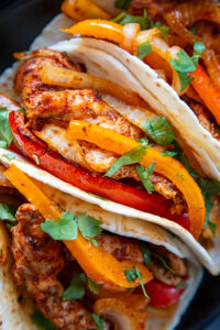 overhead close up shot of chicken fajitas in flour tortilla