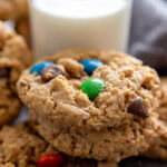 stack of monster cookies by glass of milk