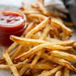 french fries in a bunch with ketchup