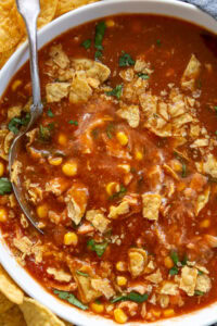 overhead shot of chicken tortilla soup. in bowl with tortilla chips