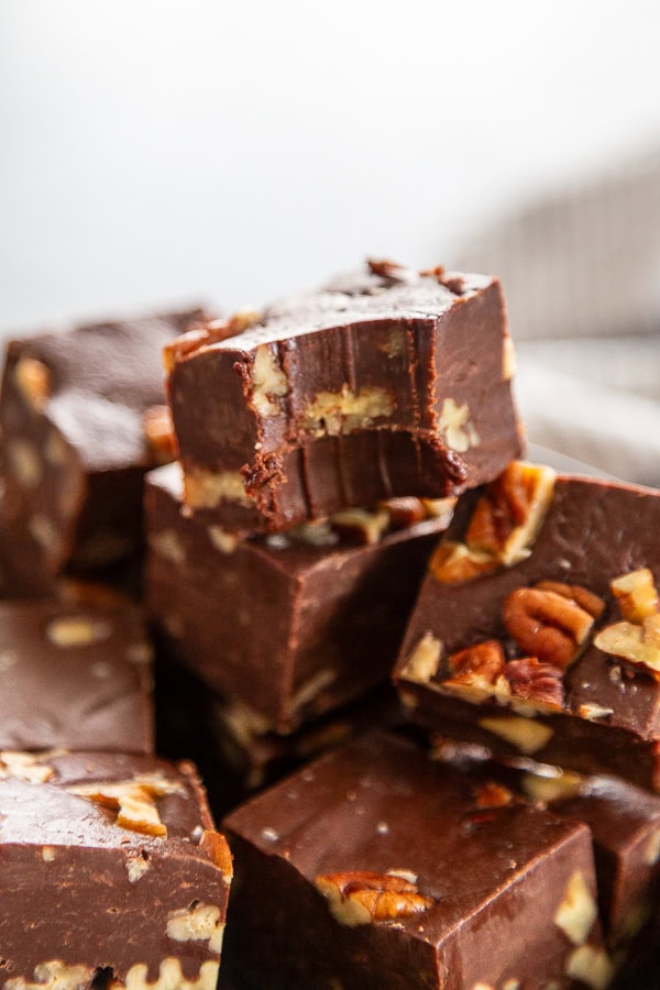 close up shot of pecan fudge in a stack with bite out of one