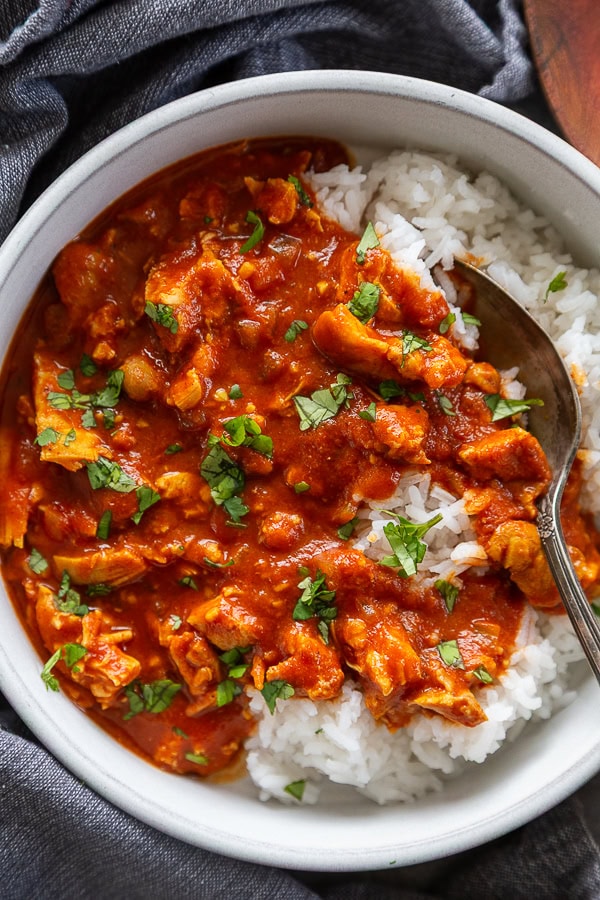 overhead shot tikka masala with white rice and cilantro in bowl