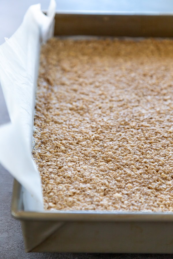 baked oat bars in baking dish lined with parchment paper