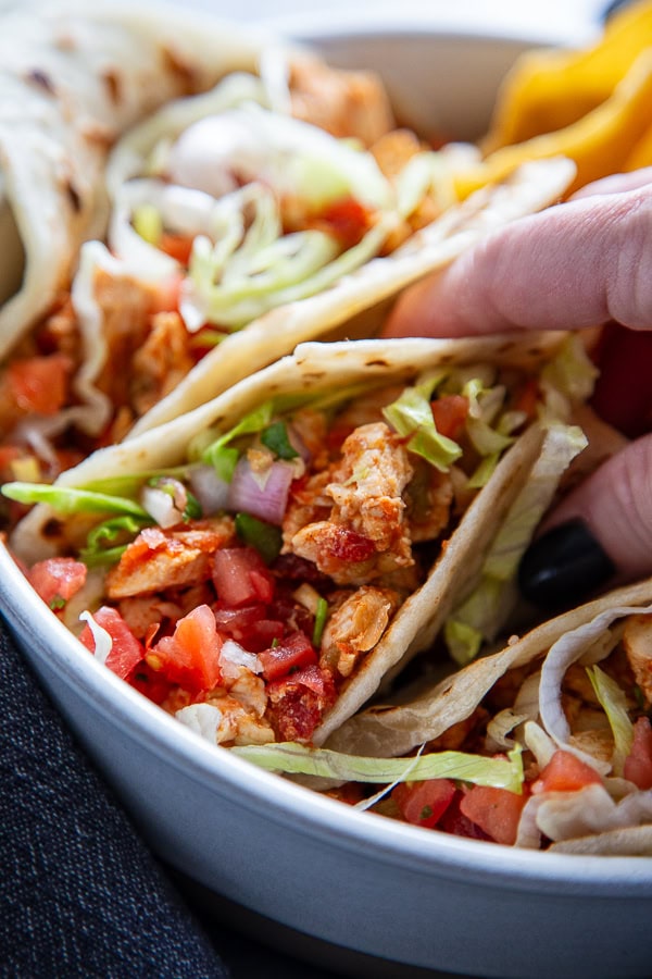close up shot of hand grabbing a taco