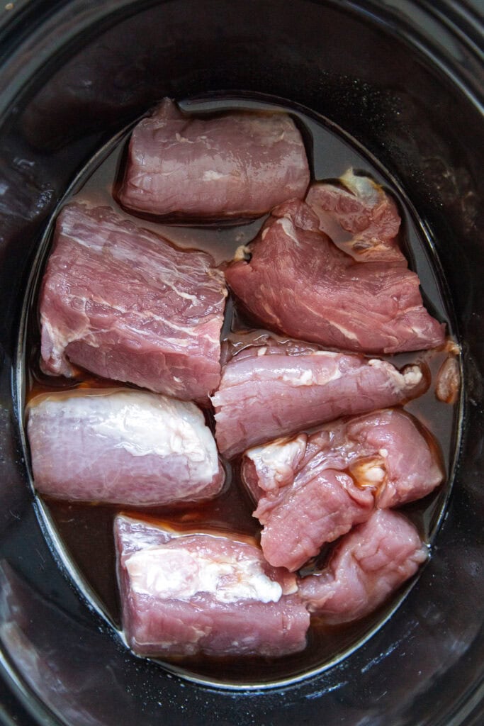 overhead shot of raw pork in slow cooker