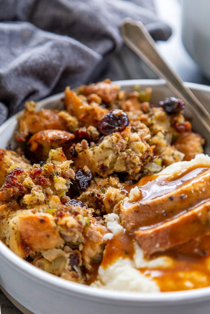 shot of plate of stuffing and turkey with mashed potatoes and gravy
