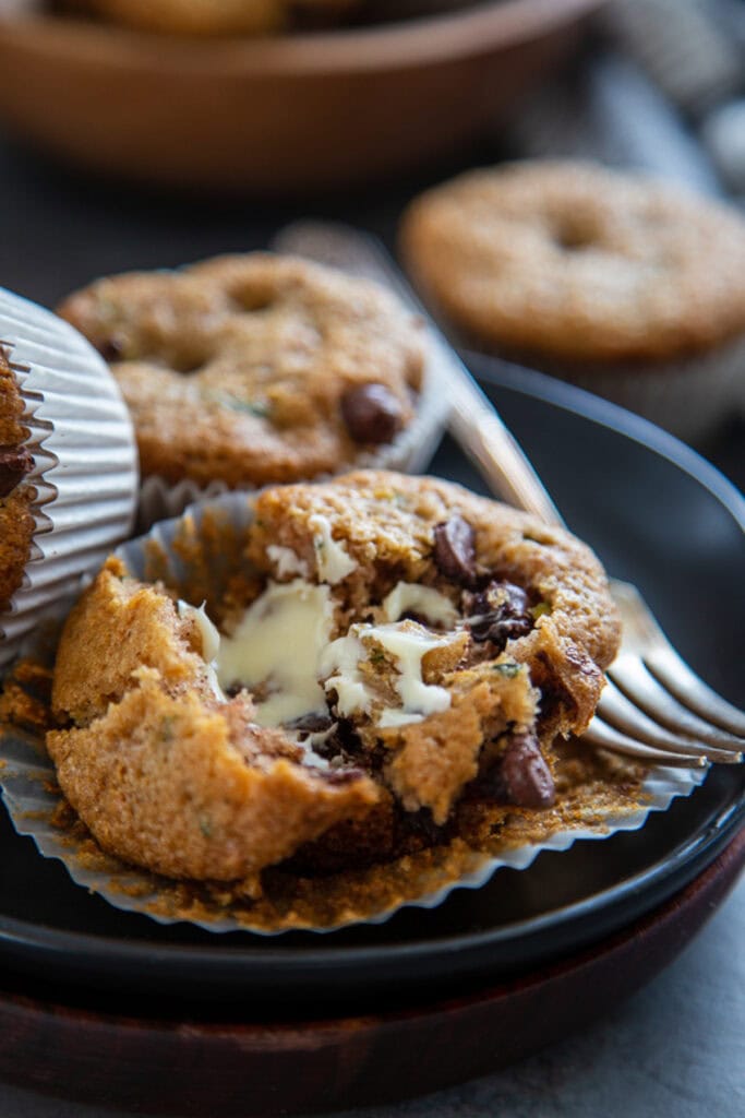 zucchini chocolate chip muffin on plate with butter